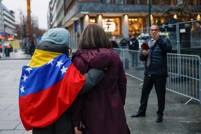 Two women, one drapped in the Venezuelan flag, are pictured prior to the Nobel Peace  Prize ceremony at Oslo City Hall on December 10, 2025 in Oslo, Norway. The director of the Nobel institute said on December 10, 2025 he was not aware where Venezuelan opposition leader Maria Corina Machado was after it was announced she would not attend the award of her Nobel Peace Prize.
The 2025 Nobel Peace Prize was awarded to Machado for her efforts to bring democracy to Venezuela, challenging the iron-fisted rule of Venezuelan President Nicolas Maduro, who has been president since 2013. (Photo by Odd ANDERSEN / AFP)