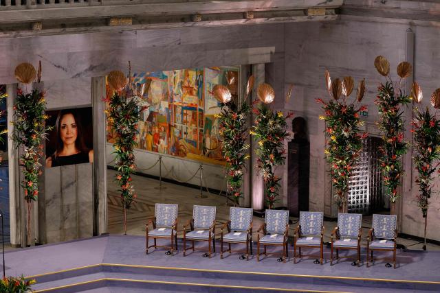 A portrait of Nobel Peace Prize 2025 laureate Venezuelan opposition leader Maria Corina Machado is on display at Oslo City Hall prior to the ceremony on December 10, 2025 in Oslo, Norway. The director of the Nobel institute said on December 10, 2025 he was not aware where Venezuelan opposition leader Maria Corina Machado was after it was announced she would not attend the award of her Nobel Peace Prize.
The 2025 Nobel Peace Prize was awarded to Machado for her efforts to bring democracy to Venezuela, challenging the iron-fisted rule of Venezuelan President Nicolas Maduro, who has been president since 2013. (Photo by Odd ANDERSEN / AFP)