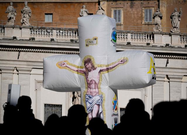 Pilgrims from the island of Ventotene carry an inflatable crucifix to St. Peter's Square at the end the weekly general audience in the Vatican on December 10, 2025. (Photo by TIZIANA FABI / AFP)