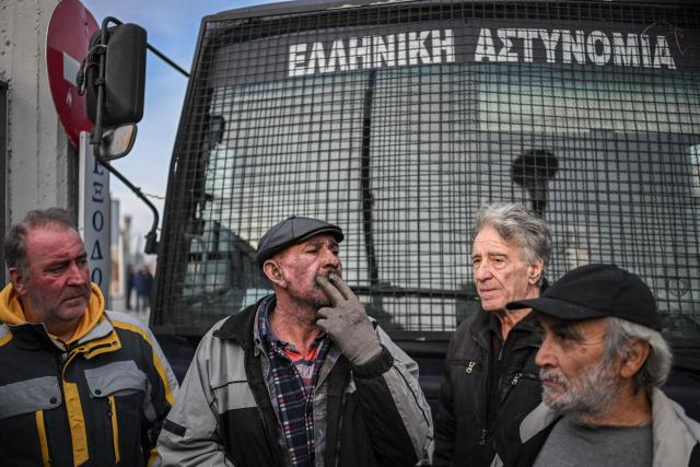 TOPSHOT - Farmers take part in the blocking of the passengers' port of the central Greek city of Volos during a demonstration on December 10, 2025. Thousands of Greek farmers have since late November 2025 blocked highways, mainly in the centre and north of the country, to demand swifter access to EU subsidies delayed by an ongoing probe into multi-million fraud. (Photo by Aris MESSINIS / AFP)
