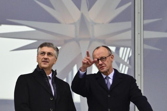 German Chancellor Friedrich Merz (R) and Croatia's Prime Minister Andrej Plenkovic chat as they stand on a balcony of the Chancellery in Berlin on December 10, 2025. (Photo by John MACDOUGALL / AFP)