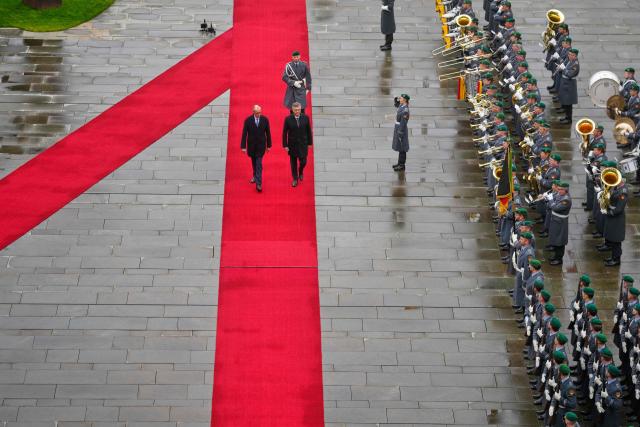German Chancellor Friedrich Merz (L) and Croatia's Prime Minister Andrej Plenkovic walk along the red carpet during a welcoming ceremony in the courtyard of the Chancellery in Berlin on December 10, 2025. (Photo by Markus Schreiber / POOL / AFP)