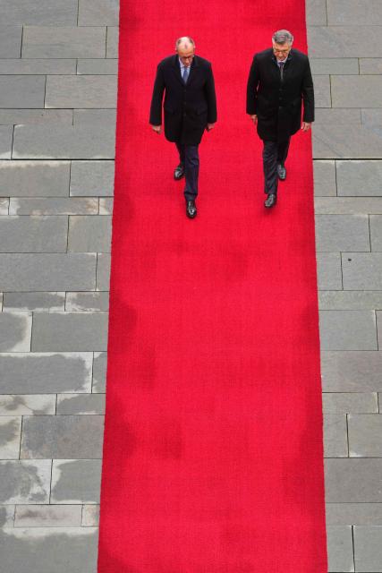German Chancellor Friedrich Merz (L) and Croatia's Prime Minister Andrej Plenkovic walk along the red carpet during a welcoming ceremony in the courtyard of the Chancellery in Berlin on December 10, 2025. (Photo by Markus Schreiber / POOL / AFP)