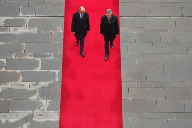 German Chancellor Friedrich Merz (L) and Croatia's Prime Minister Andrej Plenkovic walk along the red carpet during a welcoming ceremony in the courtyard of the Chancellery in Berlin on December 10, 2025. (Photo by Markus Schreiber / POOL / AFP)