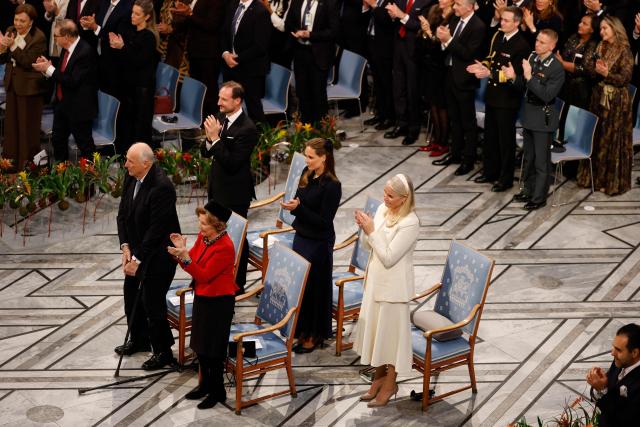 Ana Corina Sosa (not in picture), daughter of Venezuelan opposition leader Maria Corina Machado, receives a standing ovation from the audience including the members of the Norweigan royal family Norway's King Harald V, Norway's Queen Sonja, Crown Prince Haakon of Norway, Princess Ingrid Alexandra of Norway and Crown Princess Mette-Marit of Norway, following her speach after receiving the Nobel Peace Prize for her mother at the Nobel Peace Prize ceremony at Oslo City Hall on December 10, 2025 in Oslo, Norway. The 2025 Nobel Peace Prize was awarded to Machado for her efforts to bring democracy to Venezuela, challenging the iron-fisted rule of Venezuelan President Nicolas Maduro, who has been president since 2013. (Photo by Odd ANDERSEN / AFP)