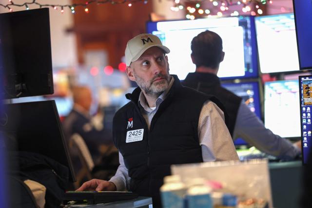 A trader works at his desk on the floor of the New York Stock Exchange (NYSE) ahead of the opening bell in New York on December 10, 2025. Stock markets mostly fell and the dollar steadied Wednesday following a tepid day on Wall Street as investors bided their time ahead of a highly anticipated Federal Reserve policy announcement later in the day. (Photo by TIMOTHY A. CLARY / AFP)