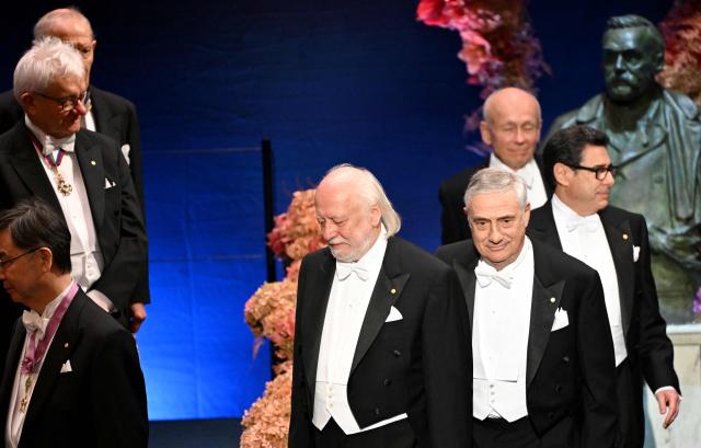 (L-R) Nobel Prize in Literature 2025 laureate Hungarian writer Laszlo Krasznahorkai, laureate of The Sveriges Riksbank Prize in Economic Sciences 2025 US-Israeli economic historian Joel Mokyr, laureate of The Sveriges Riksbank Prize in Economic Sciences 2025 French economist Philippe Aghion and laureate of The Sveriges Riksbank Prize in Economic Sciences 2025 Canadian economist Peter Howitt walk past a bust of Alfred Nobel as they arrive to attend the Nobel Prize award ceremony on December 10, 2025 in Stockholm, Sweden. The laureates will receive their prizes at formal ceremonies in Stockholm and Oslo on December 10. That date is the anniversary of the death in 1896 of scientist Alfred Nobel, who created the prizes in his will. (Photo by Jonathan Nackstrand / AFP)