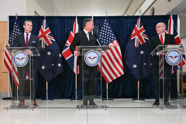 (L/R) US Secretary of Defense Pete Hegseth, Australian Deputy Prime Minister and Defense Minister Richard Marles, and Britain's Defence Secretary John Healey deliver remarks during the annual AUKUS Defense Ministers' Ministerial at the Pentagon in Washington, DC, on December 10, 2025. (Photo by Jim WATSON / AFP)