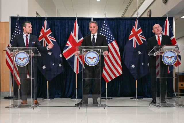 (L/R) US Secretary of Defense Pete Hegseth, Australian Deputy Prime Minister and Defense Minister Richard Marles, and Britain's Defence Secretary John Healey deliver remarks during the annual AUKUS Defense Ministers' Ministerial at the Pentagon in Washington, DC, on December 10, 2025. (Photo by Jim WATSON / AFP)