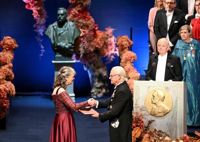 King Carl XVI Gustaf of Sweden (R) hands over the award to Nobel Prize in Physiology or Medicine 2025 laureate US molecular biologist and immunologist Mary E Brunkow during the Nobel Prize award ceremony on December 10, 2025 in Stockholm, Sweden. The laureates will receive their prizes at formal ceremonies in Stockholm and Oslo on December 10. That date is the anniversary of the death in 1896 of scientist Alfred Nobel, who created the prizes in his will. (Photo by Jonathan Nackstrand / AFP)