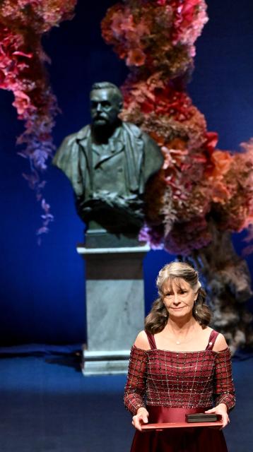 Nobel Prize in Physiology or Medicine 2025 laureate US molecular biologist and immunologist Mary E Brunkow poses with her award during the Nobel Prize award ceremony on December 10, 2025 in Stockholm, Sweden. The laureates will receive their prizes at formal ceremonies in Stockholm and Oslo on December 10. That date is the anniversary of the death in 1896 of scientist Alfred Nobel, who created the prizes in his will. (Photo by Jonathan Nackstrand / AFP)