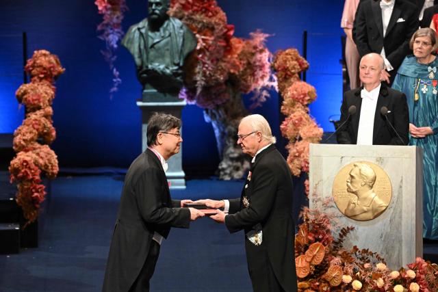 Nobel Prize in Physiology or Medicine 2025 laureate Japanese immunologist Shimon Sakaguchi is handed his award by King Carl XVI Gustaf of Sweden (R) during the Nobel award ceremony at the Concert Hall in Stockholm, Sweden on December 10, 2025. The laureates received their prizes at formal ceremonies in Stockholm and Oslo on December 10. That date is the anniversary of the death in 1896 of scientist Alfred Nobel, who created the prizes in his will. (Photo by Jonathan Nackstrand / AFP)