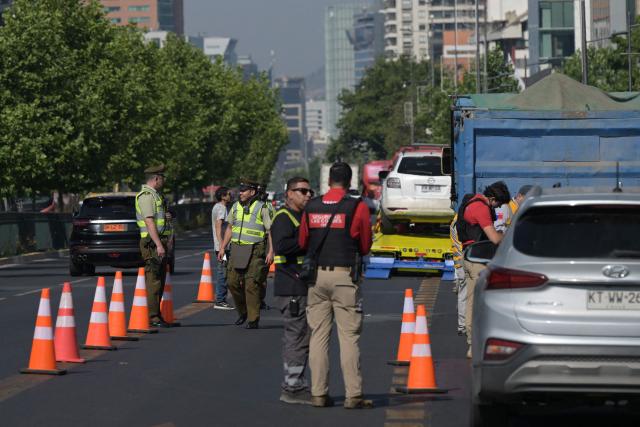 Police officers and private security from Las Condes municipality take part in a joint operation checking the ID of drivers in Santiago on December 10, 2025. The second round of the Chilean presidential election on December 14 will pit two candidates against each other who are diametrically opposed: Jeannette Jara, the representative of a broad left-wing coalition with modest origins, and the far-right leader Jose Antonio Kast, an ultraconservative Catholic determined to massively expel undocumented migrants. (Photo by Rodrigo ARANGUA / AFP)