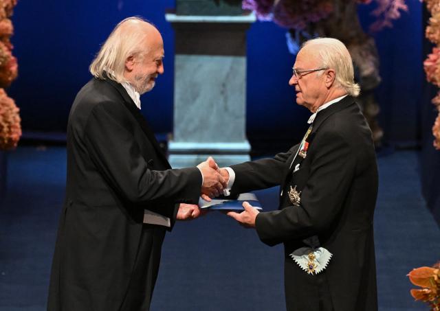 Nobel Prize in Literature 2025 laureate Hungarian writer Laszlo Krasznahorkai is handed his award by King Carl XVI Gustaf of Sweden (R) during the 2025 Nobel Prize award ceremony on December 10, 2025 in Stockholm, Sweden. The laureates received their prizes at formal ceremonies in Stockholm and Oslo on December 10. That date is the anniversary of the death in 1896 of scientist Alfred Nobel, who created the prizes in his will. (Photo by Jonathan Nackstrand / AFP) / ALTERNATIVE CROP