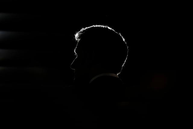 TOPSHOT - French President Emmanuel Macron's silhouette is seen during a debate titled “Democracy put to the test by social media and algorithms” with readers of the daily French newspaper Ouest-France as part of his visit to Saint-Malo on December 10, 2025. In front of nearly 220 participants gathered in a large hall, the president was asked about democracy and voting in the age of “fake news” on social media and what constitutes information. (Photo by Yoan VALAT / POOL / AFP)