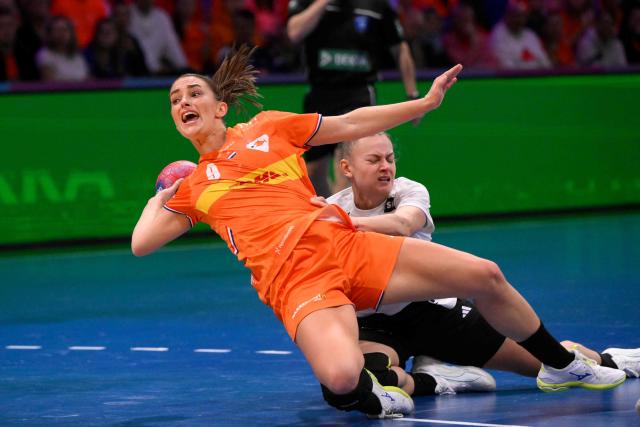 Netherlands' centre back #09 Larissa Nusser (L) is blocked by Hungary's pivot #58 Reka Bordas (R) as she tries to shoot during the quarter finals match between the Netherlands and Hungary of the IHF Women's Handball World Championship in Rotterdam Ahoy, in Rotterdam on December 10, 2025. (Photo by JOHN THYS / AFP)