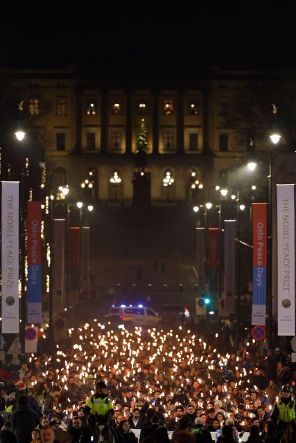 The Norwegian Venezuelan Justice Alliance and other people take part in a torchlight procession in honor of Nobel Peace Prize laureate Maria Corina Machado in Oslo, Norway, on December 10, 2025. The daughter of the Nobel Peace Prize laureate, Ana Corina Sosa, accepted the award on behalf of her mother during a ceremony at Oslo City Hall. Venezuelan opposition leader Maria Corina Machado received the award for her tireless work to secure democratic rights for the people of Venezuela, and for her fight for a just and peaceful transition from dictatorship to popular rule. Due to the circumstances in her home country of Venezuela, the Nobel Peace Prize laureate was unable to attend the award ceremony in Norway. (Photo by Odd ANDERSEN / AFP) / Norway OUT