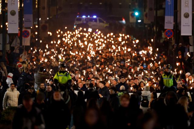 The Norwegian Venezuelan Justice Alliance and other people take part in a torchlight procession in honor of Nobel Peace Prize laureate Maria Corina Machado in Oslo, Norway, on December 10, 2025. The daughter of the Nobel Peace Prize laureate, Ana Corina Sosa, accepted the award on behalf of her mother during a ceremony at Oslo City Hall. Venezuelan opposition leader Maria Corina Machado received the award for her tireless work to secure democratic rights for the people of Venezuela, and for her fight for a just and peaceful transition from dictatorship to popular rule. Due to the circumstances in her home country of Venezuela, the Nobel Peace Prize laureate was unable to attend the award ceremony in Norway. (Photo by Odd ANDERSEN / AFP) / Norway OUT