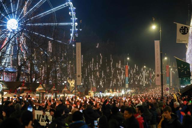 People attend a torchlight procession organises by the Norwegian Venezuelan Justice Alliance in honor of Nobel Peace Prize laureate Maria Corina Machado in Oslo, Norway, on December 10, 2025. The daughter of the Nobel Peace Prize laureate, Ana Corina Sosa, accepted the award on behalf of her mother during a ceremony at Oslo City Hall. Venezuelan opposition leader Maria Corina Machado received the award for her tireless work to secure democratic rights for the people of Venezuela, and for her fight for a just and peaceful transition from dictatorship to popular rule. Due to the circumstances in her home country of Venezuela, the Nobel Peace Prize laureate was unable to attend the award ceremony in Norway. (Photo by Amanda Pedersen Giske / NTB / AFP) / Norway OUT