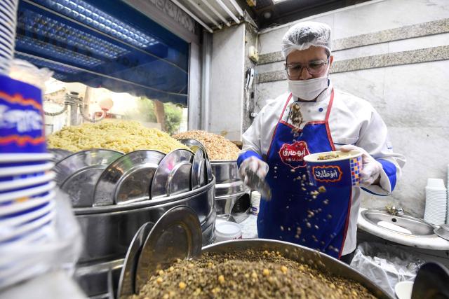 An Egyptian chef prepares a traditional dish in Arabic known as Koshary at Abou Tarek restaurant downtown Cairo on December 10, 2025. UNESCO recognised December 10 Egypt's favourite daily dish as intangible cultural heritage, to the delight of Egyptians digging into the spicy staple at every corner. (Photo by Ahmed HASAN / AFP)