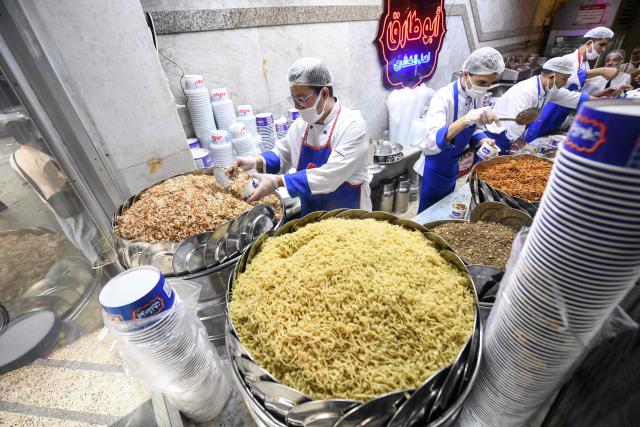 Egyptian chefs prepare a traditional dish in Arabic known as Koshary at Abou Tarek restaurant downtown Cairo on December 10, 2025. UNESCO recognised December 10 Egypt's favourite daily dish as intangible cultural heritage, to the delight of Egyptians digging into the spicy staple at every corner. (Photo by Ahmed HASAN / AFP)