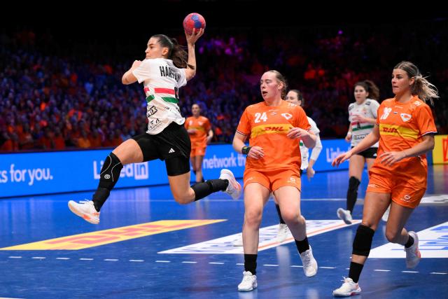 Hungary's left wing #09 Julia Harsfalvi (L) jumps to shoot during the quarter finals match between the Netherlands and Hungary of the IHF Women's Handball World Championship in Rotterdam Ahoy, in Rotterdam on December 10, 2025. (Photo by JOHN THYS / AFP)