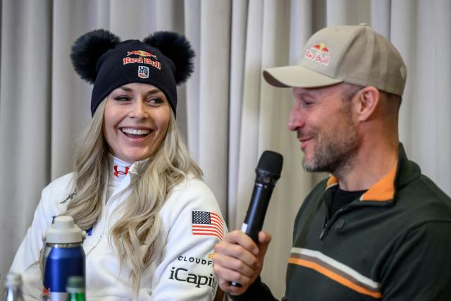 US Lindsey Vonn (L) listens to her coach, former Norwegian skier Aksel Lund Svindal (R) addressing media during a press conference ahead of speed skiing races as part of the FIS Alpine ski World Cup 2025-2026, in St. Moritz on December 10, 2025. (Photo by Fabrice COFFRINI / AFP)
