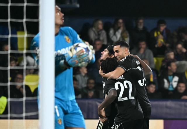 FC Copenhagen's Tunisian forward #30 Elias Achouri celebrates scoring his team's second goal with teammates in spite of Villarreal's Brazilian goalkeeper #01 Luiz Junior during the UEFA Champions League league phase day 6 football match between Villarreal CF and FC Copenhagen at La Ceramica Stadium in Vila-real on December 10, 2025. (Photo by JOSE JORDAN / AFP)