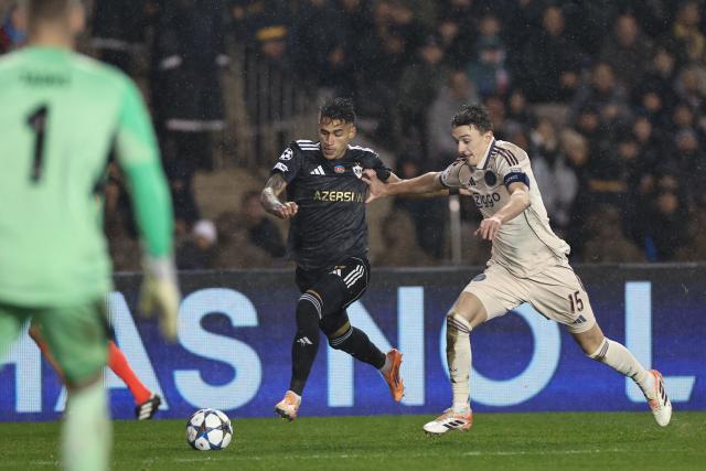 Qarabag's Colombian forward Camilo Duran and Ajax's Dutch defender #15 Youri Baas vie for the ball during the UEFA Champions League league phase football match between Qarabag and Ajax at the Tofiq Bahramov Republican Stadium in Baku on December 10, 2025. (Photo by Giorgi ARJEVANIDZE / AFP)