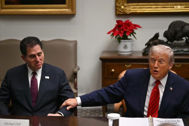 US President Donald Trump (R) gestures toward CEO of Dell Technologies Michael Dell as he speaks during a roundtable discussion in the Roosevelt Room of the White House in Washington, DC, on December 10, 2025. (Photo by ANDREW CABALLERO-REYNOLDS / AFP)