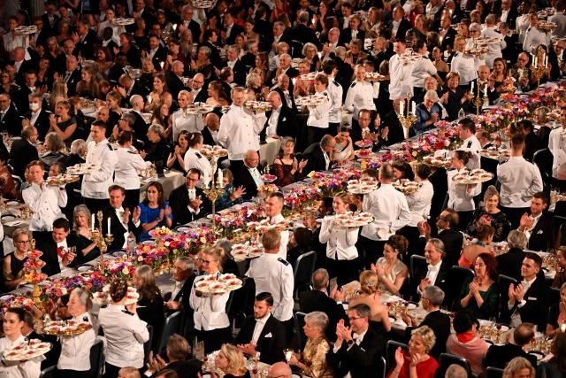 Waiters serve the dessert during the Nobel Prize banquet on December 10, 2025 at the City Hall in Stockholm, Sweden. The laureates received their prizes at formal ceremonies in Stockholm and Oslo on December 10. That date is the anniversary of the death in 1896 of scientist Alfred Nobel, who created the prizes in his will. (Photo by Jonathan Nackstrand / AFP)