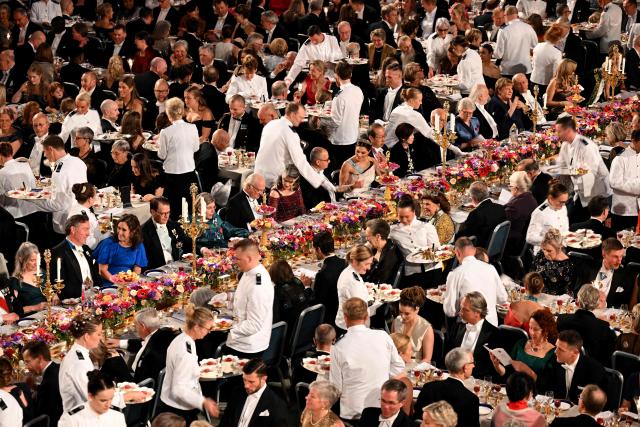 Waiters serve the dessert during the Nobel Prize banquet on December 10, 2025 at the City Hall in Stockholm, Sweden. The laureates received their prizes at formal ceremonies in Stockholm and Oslo on December 10. That date is the anniversary of the death in 1896 of scientist Alfred Nobel, who created the prizes in his will. (Photo by Jonathan Nackstrand / AFP)