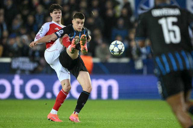 Arsenal's Danish midfielder #16 Christian Norgaard (L) and Club Brugge's German forward #07 Nicolo Tresoldi (C) fight for the ball during the UEFA Champions League, league phase - matchday 6, football match between Club Brugge and Arsenal at the Jan Breydel stadium in Bruges on December 10, 2025. (Photo by NICOLAS TUCAT / AFP)