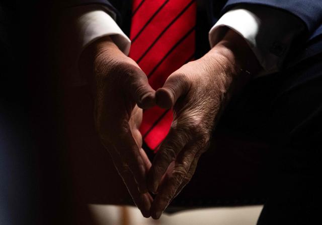 US President Donald Trump holds his hands together as he speaks during a roundtable discussion in the Roosevelt Room of the White House in Washington, DC, on December 10, 2025. (Photo by ANDREW CABALLERO-REYNOLDS / AFP)