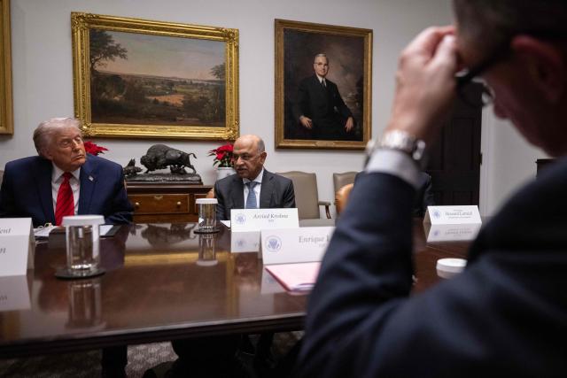 US President Donald Trump (L) looks on as CEO of IBM Arvind Krishna (R) speaks during a roundtable discussion in the Roosevelt Room of the White House in Washington, DC, on December 10, 2025. (Photo by ANDREW CABALLERO-REYNOLDS / AFP)