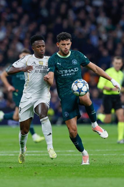 Real Madrid's Brazilian forward #07 Vinicius Junior (L) and Manchester City's Portuguese midfielder #27 Matheus Nunes vie for the ball during the UEFA Champions League league phase day 6 football match between Real Madrid CF and Manchester City at Santiago Bernabeu Stadium in Madrid on December 10, 2025. (Photo by Oscar DEL POZO / AFP)