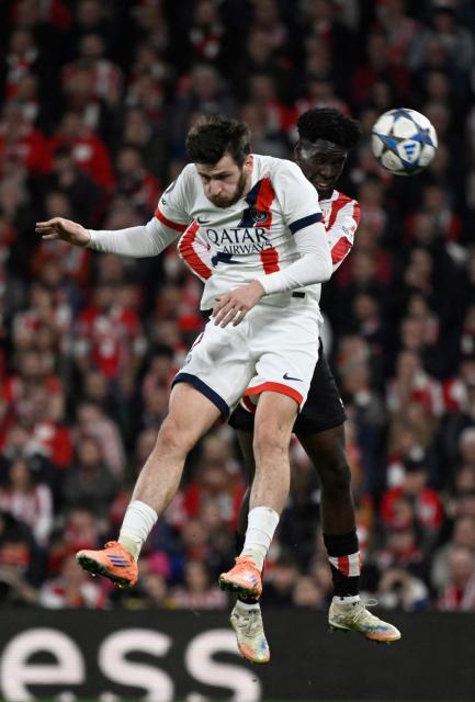 Paris Saint-Germain's Georgian forward #07 Khvicha Kvaratskhelia and Athletic Bilbao's Spanish defender #19 Adama Boiro vie for a header during the UEFA Champions League league phase day 6 football match between Athletic Club Bilbao and Paris Saint-Germain (PSG) at San Mames Stadium in Bilbao on December 10, 2025. (Photo by ANDER GILLENEA / AFP)