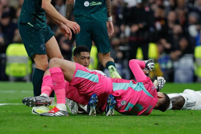 Manchester City's Italian goalkeeper #25 Gianluigi Donnarumma lies onn top of Real Madrid's English midfielder #05 Jude Bellingham during the UEFA Champions League league phase day 6 football match between Real Madrid CF and Manchester City at Santiago Bernabeu Stadium in Madrid on December 10, 2025. (Photo by Oscar DEL POZO / AFP)