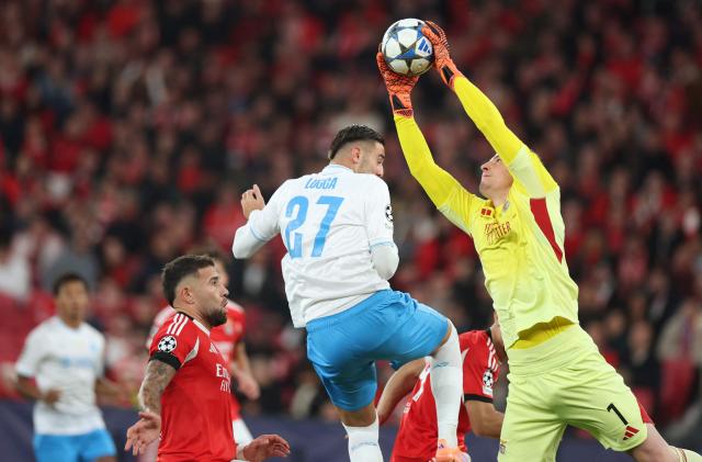 Napoli's Italian forward #27 Lorenzo Lucca and Benfica's Ukrainian goalkeeper #01 Anatoliy Trubin fight for the ball during the UEFA Champions League league phase day 6 football match between SL Benfica and Napoli at Estadio da Luz in Lisbon on December 10, 2025. (Photo by PATRICIA DE MELO MOREIRA / AFP)