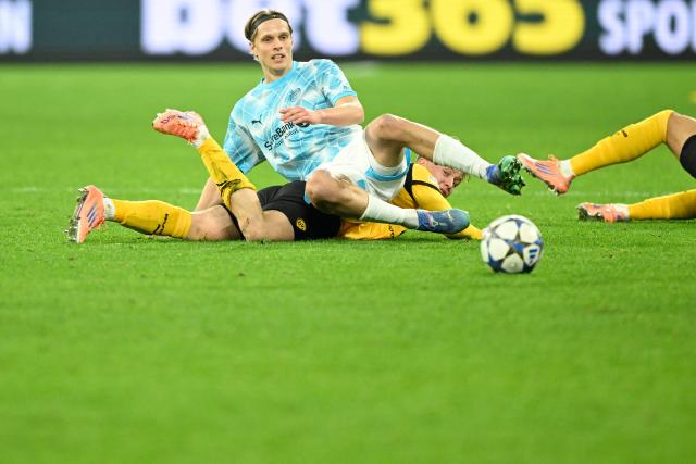 Bodoe/Glimt's Norwegian midfielder #14 Ulrik Saltnes (top) and Dortmund's Swedish defender #24 Daniel Svensson (bottom) crash during the UEFA Champions League league phase day 6 football match between Borussia Dortmund and Bodoe/Glimt in Dortmund, western Germany, on December 10, 2025. (Photo by INA FASSBENDER / AFP)