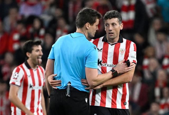 Athletic Bilbao's Spanish midfielder #06 Mikel Vesga talks with the referee during the UEFA Champions League league phase day 6 football match between Athletic Club Bilbao and Paris Saint-Germain (PSG) at San Mames Stadium in Bilbao on December 10, 2025. (Photo by ANDER GILLENEA / AFP)