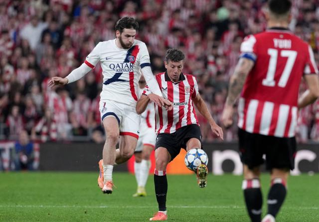 Paris Saint-Germain's Georgian forward #07 Khvicha Kvaratskhelia fights for the ball with Athletic Bilbao's Spanish midfielder #06 Mikel Vesga during the UEFA Champions League league phase day 6 football match between Athletic Club Bilbao and Paris Saint-Germain (PSG) at San Mames Stadium in Bilbao on December 10, 2025. (Photo by Cesar MANSO / AFP)
