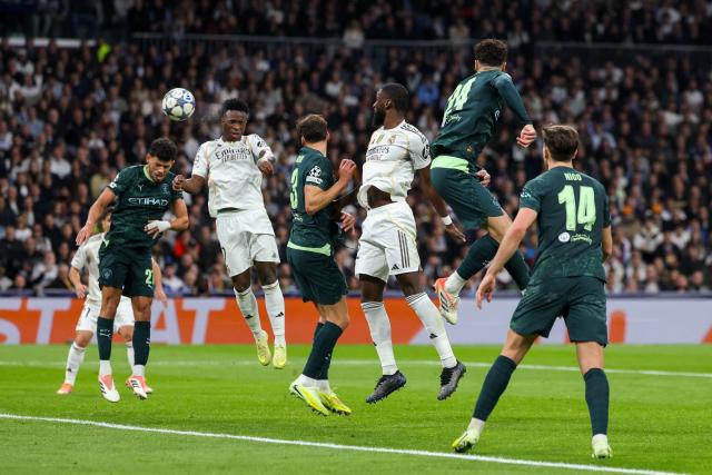 Manchester City's Portuguese midfielder #27 Matheus Nunes (L) and Real Madrid's Brazilian forward #07 Vinicius Junior go for a header during the UEFA Champions League league phase day 6 football match between Real Madrid CF and Manchester City at Santiago Bernabeu Stadium in Madrid on December 10, 2025. (Photo by Thomas COEX / AFP)