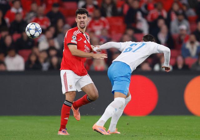 Benfica's Portuguese defender #44 Tomas Araujo and Napoli's Italian forward #27 Lorenzo Lucca fight for the ball during the UEFA Champions League league phase day 6 football match between SL Benfica and Napoli at Estadio da Luz in Lisbon on December 10, 2025. (Photo by FILIPE AMORIM / AFP)