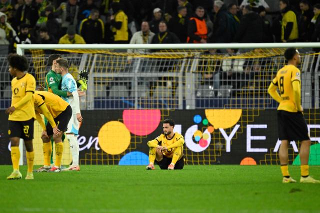 Dortmund's Algerian defender #05 Ramy Bensebaini (C) and other players react after the end of the UEFA Champions League league phase day 6 football match between Borussia Dortmund and Bodoe/Glimt in Dortmund, western Germany, on December 10, 2025. (Photo by INA FASSBENDER / AFP)