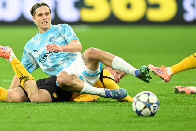 Bodoe/Glimt's Norwegian midfielder #14 Ulrik Saltnes (top) and Dortmund's Swedish defender #24 Daniel Svensson (bottom) crash during the UEFA Champions League league phase day 6 football match between Borussia Dortmund and Bodoe/Glimt in Dortmund, western Germany, on December 10, 2025. (Photo by INA FASSBENDER / AFP)