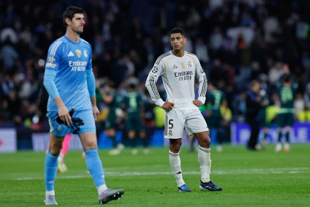 Real Madrid's English midfielder #05 Jude Bellingham (R) and Real Madrid's Belgian goalkeeper #01 Thibaut Courtois react after the UEFA Champions League league phase day 6 football match between Real Madrid CF and Manchester City at Santiago Bernabeu Stadium in Madrid on December 10, 2025. (Photo by Oscar DEL POZO / AFP)
