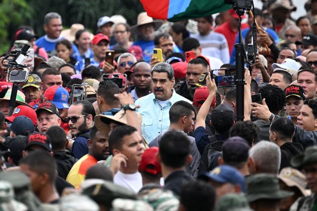 Venezuela's President Nicolas Maduro (C) arrives at a rally marking the anniversary of the Battle of Santa Ines, in Caracas on December 10, 2025. (Photo by Federico PARRA / AFP)
