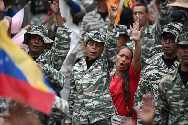 Members of the Bolivarian National Militia take part in a rally to mark the anniversary of the Battle of Santa Ines, in Caracas on December 10, 2025. (Photo by Federico PARRA / AFP)