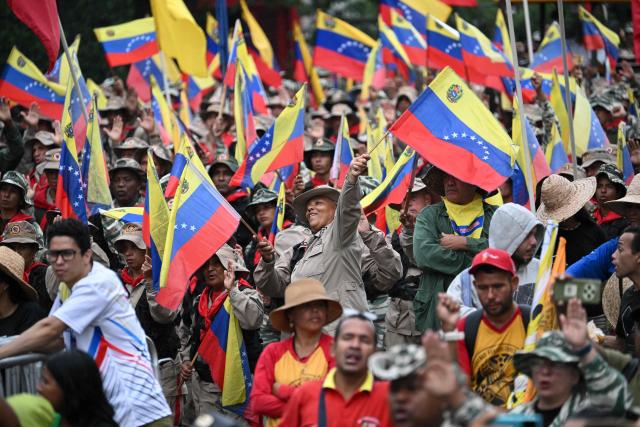 Members of the Bolivarian National Militia take part in a rally to mark the anniversary of the Battle of Santa Ines, in Caracas on December 10, 2025. (Photo by Federico PARRA / AFP)